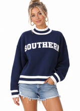 Load image into Gallery viewer, A woman modeling a navy blue crewneck sweatshirt with white stripes and 'SOUTHERN' printed across the chest, paired with denim shorts, against a plain white background.